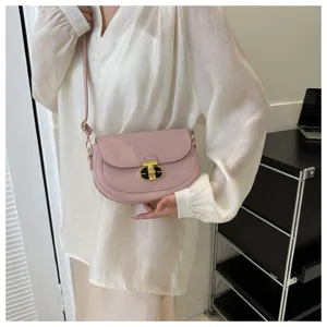 Chic pink shoulder saddle bag with metal lock closure, elegant everyday crossbody style.