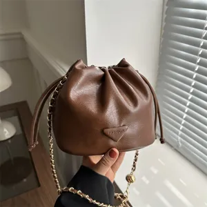 Stylish brown leather bucket bag with chain strap, perfect women's winter crossbody bag.