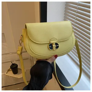 Yellow saddle crossbody bag detail view, stylish lock closure, premium shoulder bag