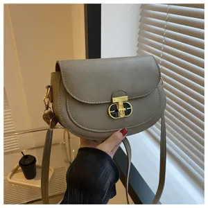 Gray saddle shoulder bag with golden lock clasp, stylish casual crossbody bag for women daily use.
