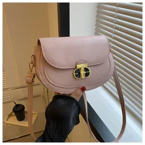 Pink PU leather crossbody saddle bag featuring a chic gold tone turn lock closure and strap.