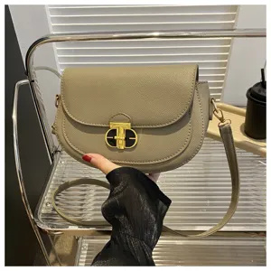 Stylish women saddle shoulder bag taupe PU leather crossbody bag with metal lock for daily wear.