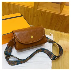 Trendy vintage shoulder bag for women with wide patterned strap and elegant flower clasp.