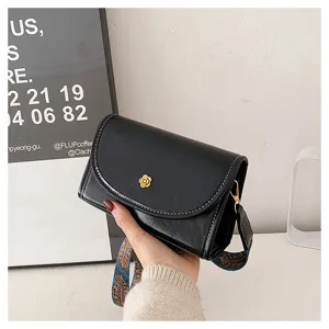 Black PU leather shoulder bag detail showcase with gold floral clasp and ethnic strap.