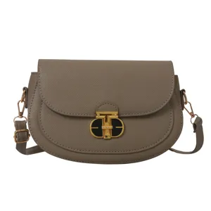 Detailed view of stylish gray leather saddle bag featuring elegant golden lock hardware.