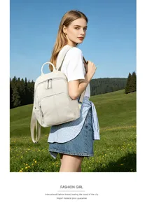 Outdoor detail shot of women's soft leather backpack, minimalist design with secure zipper pockets.