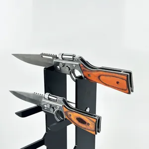 Stainless steel folding pocket knife with wood grain handle displayed on a sleek black stand.