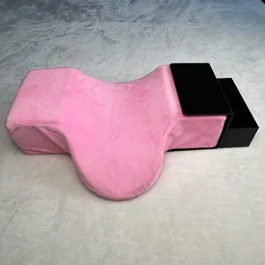 Pink eyelash extension memory pillow with black acrylic organizer shelf for salon lash tech.