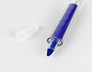 Close-up van creatieve spuitvormige markeerstift met transparante schaalcilinder en blauwe inkt.