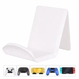 Vue détaillée du support d'affichage acrylique pour manette et téléphone, rangement blanc de bureau.