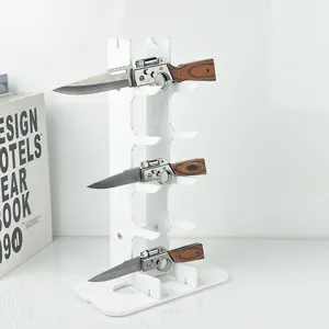 White acrylic multi-layer pocket knife display stand with folding utility knives for home storage.