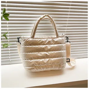 Detailed view of the quilted puffer crossbody tote bag showcasing soft shiny fabric texture.