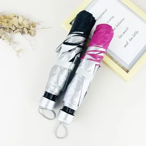 Parapluie pliant compact avec revêtement argenté anti-UV, idéal pour le soleil et la pluie.