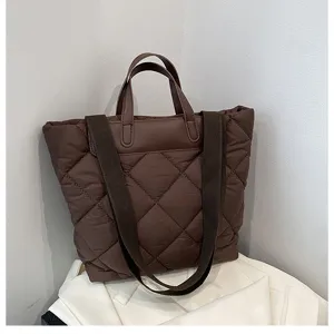 Detailed view of the brown quilted tote bag showing its large capacity and soft down cotton fabric.