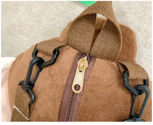 Dettaglio zaino in peluche marrone, morbido zaino imbottito con cerniera e cinghie regolabili.