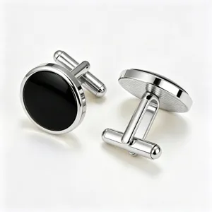 Detailed view of classic round silver metal cufflinks featuring black enamel inserts and textures.