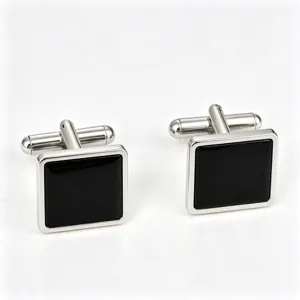 Close-up detail of square black and silver metal cufflinks for men's French dress shirts.