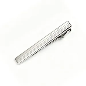 Detailed close-up of a silver metal tie clip featuring a fine laser-etched grid pattern.