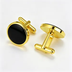 Close-up detail of golden round metal cufflinks with black enamel inlay for men's dress shirts.