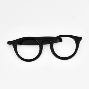Close-up detail of black eyeglasses shape tie clip, stylish and unique gentleman accessory.
