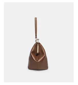 Brown leather frame clutch bag detail, featuring elegant metal clasp and modern design.