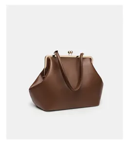 Large brown leather kiss lock handbag with gold tone metal frame and top handles for women.