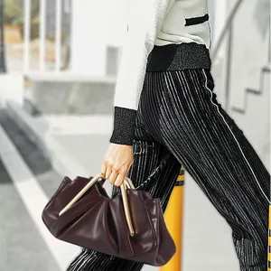 Detail shot of the stylish pleated cloud bag with unique metal handles in deep brown.