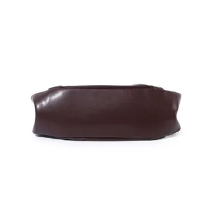 Detail view of dark brown leather cloud bag bottom showing smooth texture and craftsmanship.