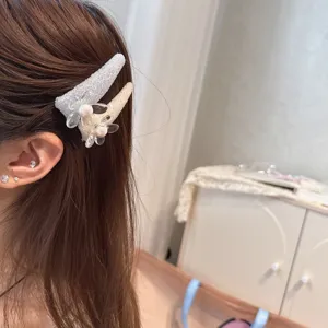 Detailed view of sparkly rhinestone pearl hair clip, sweet floral design for side bangs.