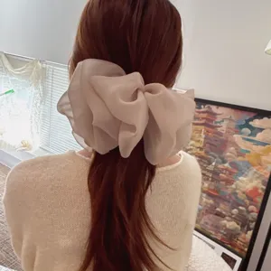Détail de pince à cheveux nœud en tulle oversize, barrette élégante pour queues de cheval.