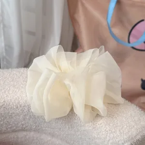 Gros plan d'un grand nœud de cheveux en résille blanche avec une texture de tissu fine.