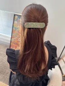 Detailed view of the Korean acetate polka dot large duckbill hair clip worn in hair.