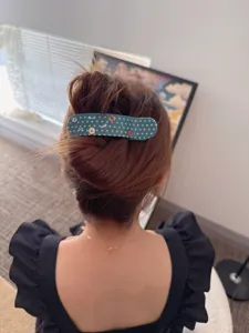 Detailed back view showing the Korean acetate polka dot large hair clip styling on hair.