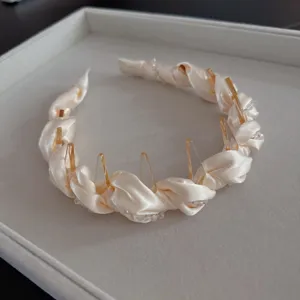 Close-up detail view of the satin crystal intertwined hair hoop with clear teeth design.