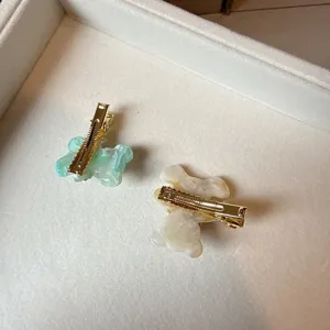 Detailed view of sweet cute acetate bear hair clips with shiny gold duckbill clips.