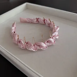 Detailed shot of pink crystal wrapped satin hair hoop, elegant women daily accessory.