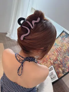 Detailed view of sparkling rhinestone snake hair claw clip, stylish back hair accessory.
