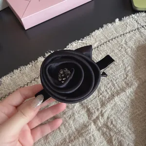 Black fabric rose hair clip with rhinestone center, elegant duckbill clip for women.
