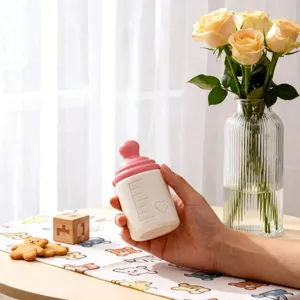 Close-up detail of the cute pink and white baby bottle container mold with heart and scale.