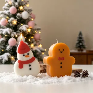 Close-up detail of cute Christmas snowman and gingerbread man scented candles, festive decor.
