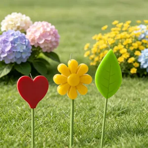 Gros plan de bougies décoratives mignonnes en forme de cœur, de fleur et de feuille sur pelouse.