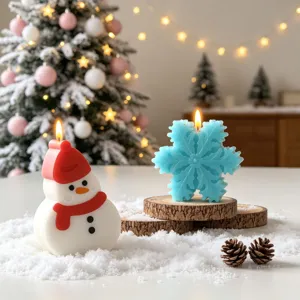 Detailed close-up of handmade Christmas snowman and blue snowflake scented candles on snow.