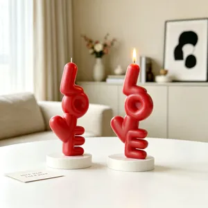 Red LOVE letter shaped scented decorative candles with white round stands for home decor.