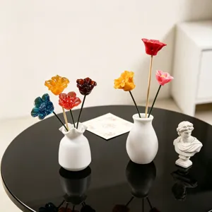 Close-up detail of colorful resin epoxy flower bonsai in white ceramic vase, desktop decor.