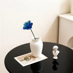 Elegant blue glass flower in white vase table decor ornament for modern home interior styling.
