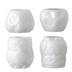 Detail van de witte uilenpot met fijn reliëf van veren en hoogwaardige afwerking.
