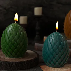 Gros plan de bougies en œuf de dragon texturées avec mèche allumée dans un style fantastique.