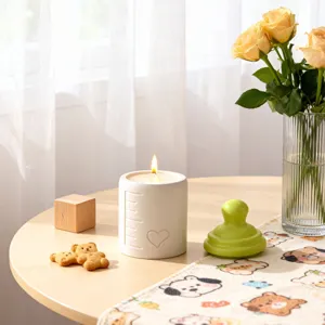 Minimalist white baby bottle candle jar with heart and scale design, perfect home decor piece.