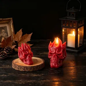 Primo piano dettagliato di candele profumate a teschio di fiamma rossa su tavolo di legno.