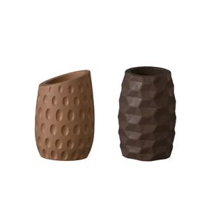 Gros plan détaillé de pots de fleurs en silicone à motifs géométriques et texturés.